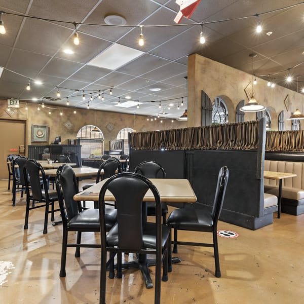 Interior of Manuel's El Burrito Restaurant, showing dining tables, chairs, booths, and string lights.