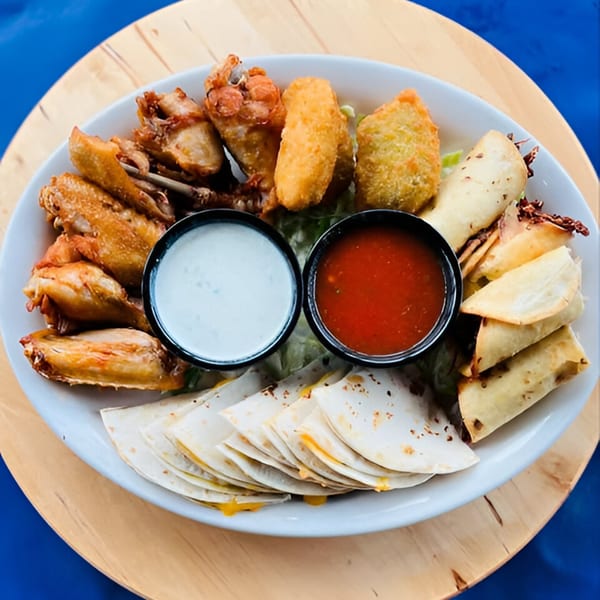 Manuel's El Burrito appetizer platter with chicken wings, taquitos, quesadillas, and dipping sauces.