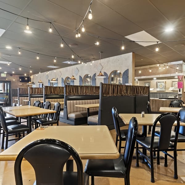 Interior of Manuel's El Burrito Restaurant & Cantina with tables, booths, and string lights.