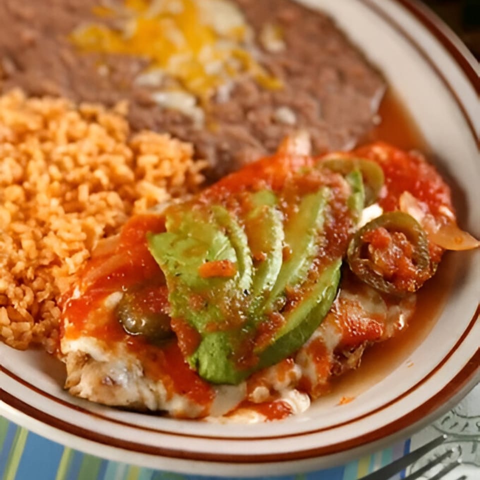 Manuel's El Burrito's Mexican dish with rice, refried beans, and a main course topped with avocado and salsa.
